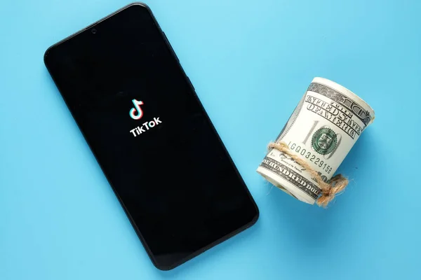 Kuala Lumpur, Malezya-Circa Haziran 2021: Akıllı telefon ve sahte parayla çekilmiş Tik Tok resmi. TikTok konseptiyle kazanç.