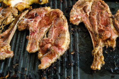 Raw sliced mutton marinated and grilled on hot plate.