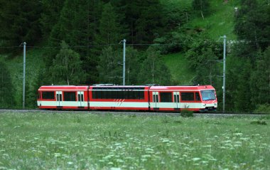 A motion blur with panning shot of Zermatt shuttle train in the morning clipart