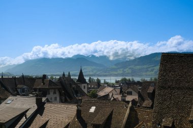 A picture of houses roof in Rapperswil old town with lake and bridge insight.
