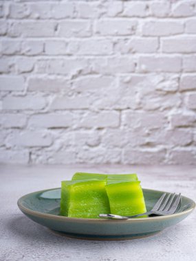 Tabakta tatlı pasta (veya khanom Chan) ve gri taş zemin üzerinde küçük çatal. Mesaj için yer var. Tayland tatlısı. Seçici odaklanma. Rahatlama zamanı. Tatlı kavramı