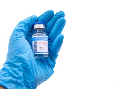 Avuçta COVID 19 aşısı ve beyaz arka planda mavi eldiven takan bir el. Mesaj için yer var. Sağlık ve Tıp Konsepti.