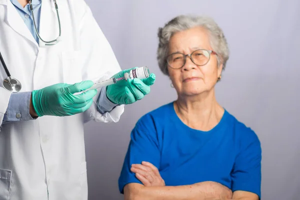 医生给医院里的一位老年妇女打了针 有选择的重点 高级疫苗接种概念 — 图库照片