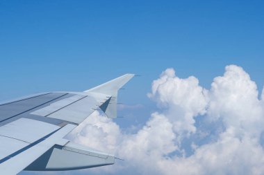 Uçak penceresinden görülen bulutlu hava manzarası. Metin için boşluk.
