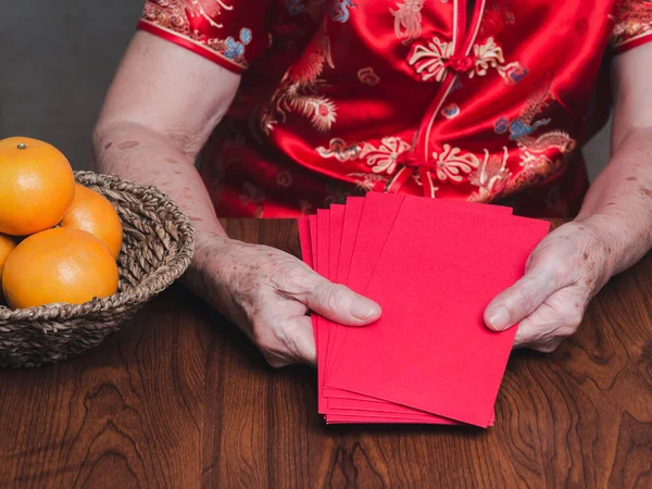 Hands Senior Woman Holding Red Envelopes Angpao Wearing Traditional Cheongsam — стоковое фото
