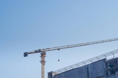 Construction site with the crane on sky background. Big yellow machinery construction crane tool of building industry for heavy lifting. Business engineering equipment modern.