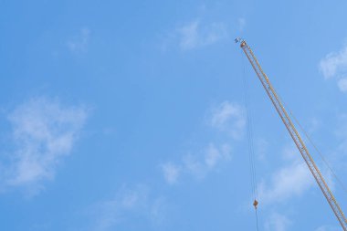 Construction site with the crane on sky background. Big yellow machinery construction crane tool of building industry for heavy lifting. Business engineering equipment modern.