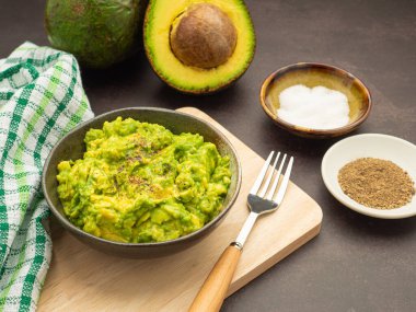 Avokado, limon, tuz ve biber gibi ev yapımı guacamole malzemeleriyle ahşap bir tahtanın üzerine konmuş taze guacamole. Üst Manzara. Geleneksel Meksika hazırlığı kavramı