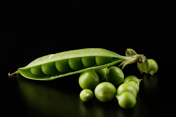 暗い背景に開いている緑のエンドウ豆のポッド — ストック写真
