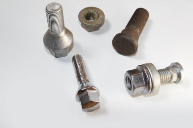 Beyaz arka plana saçılmış fındıklı farklı cıvatalar. Beyaz arkaplanda sürgüler.