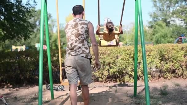 Papa Rollt Kinder Auf Einer Schaukel Gemeinsamer Spaziergang Mit Kindern — Stockvideo