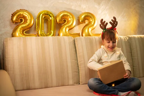 Szczęśliwa Dziewczyna Bożonarodzeniową Opaską Otwiera Pudełko Prezentami Tle Złote Numery — Zdjęcie stockowe