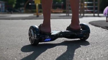 Gün batımında elektrikli scooter ya da e-scooterla şehir merkezini keşfetmeye hazır genç adama yaklaş..