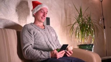 Bir adam, Noel ve yeni yıl için ailesi ve sevdiği kadın için akıllı telefon kullanarak online bir mağazadan hediye sipariş eder. çevrimiçi alışveriş kavramı
