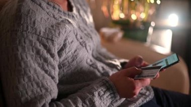 Yakın plan bir adam akıllı telefon kullanarak bir online mağazadan hediye sipariş eder. çevrimiçi alışveriş kavramı