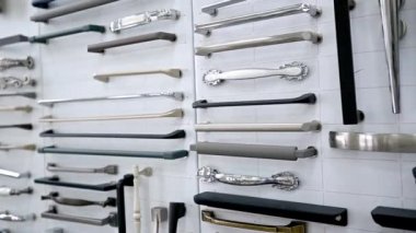 Beyaz bir arka plan vitrinindeki dolapların parçalarından oluşan büyük bir koleksiyon. Ahşap mutfak dolabında farklı paslanmaz çelik saplı metal ve paslanmaz çelik örnekleri var..
