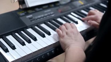 Elektronik Klavyede Elle Çalma Notaları. Kopya alanı seçici odak noktası. Güzel Piyano Melodisi. Kadın ellerinin piyanoda en sevdiği klasik müziği çalmasını yakından izleyin. Müzik aleti