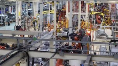 BELARUS, BORISOV - 29 Eylül 2021: Fabrikadaki modern otomobil montajı, araba gövdesi kaynaklama süreci, çalışan robotlar, otomatikleştirilmiş üretim hattında üretim süreci