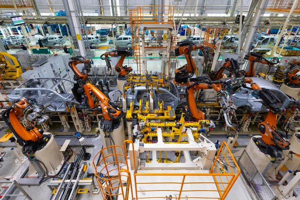 Linha de montagem em uma fábrica de carros, soldagem com robôs, trabalho automatizado — Fotografia de Stock