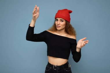 Genç, duygusal tatminsiz, güzel esmer, dalgalı saçlı, samimi duyguları olan, siyah bluz giyen ve mavi arka planda izole edilmiş kırmızı şapkalı bir kadın. Kavramı anlamıyorum.