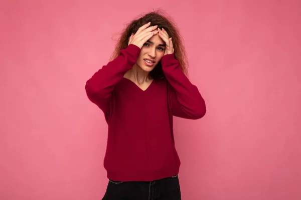 รูปภาพของสาวสวยอารมณ์สีน้ําตาล curly ผู้หญิงที่มีอารมณ์ที่จริงใจสวม pullover สีชมพูอินเทรนด์โดดเดี่ยวบนพื้นหลังสีชมพูที่มีพื้นที่สําเนาและมีอาการปวดหัว — ภาพถ่ายสต็อก