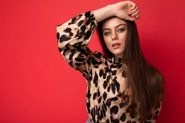 Foto de moda de la joven hermosa mujer morena sexy de moda con elegante blusa de leopardo aislado sobre fondo rojo con espacio vacío — Foto de Stock