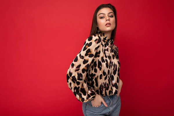 Detailní záběr portrét mladé hezké atraktivní půvabné brunet žena na sobě leopard halenka izolované na červeném pozadí s volným prostorem — Stock fotografie