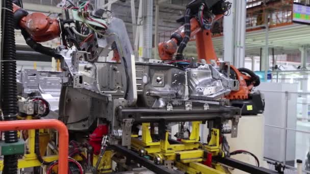 Soldadura del compartimento del motor de la carrocería de un coche nuevo en un transportador utilizando un robot, una planta moderna — Vídeo de stock