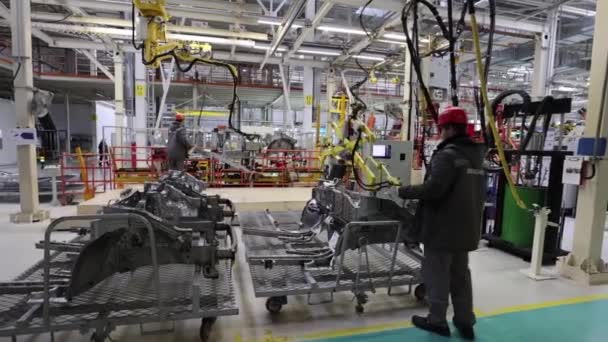 Borisov, Bielorrusia - 29 de octubre de 2021: fábrica de automóviles moderna, los trabajadores instalan piezas de automóviles — Vídeos de Stock