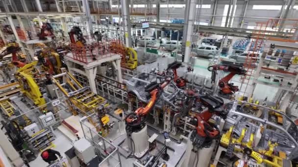 Algemeen plan van een fabriek voor de productie van auto 's op een automatische lijn met robots — Stockvideo