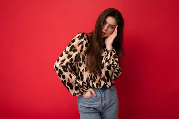 Photo of young beautiful fashionable sexy brunette woman wearing stylish leopard blouse isolated on red background with empty space — Stock Photo, Image