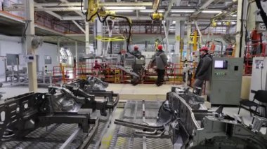 Borisov, Belarus - 29 Ekim 2021: fabrikadaki işçiler vinçli, modern bir fabrika ile parça taşıyorlar