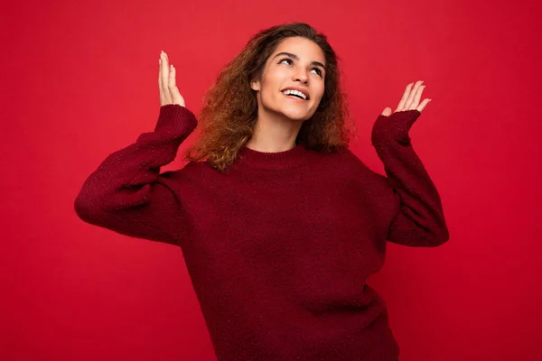 Νέοι όμορφη σγουρά μελαχρινή γυναίκα με ειλικρινή συναισθήματα poising απομονωμένη στο παρασκήνιο τοίχο με αντίγραφο χώρου φορώντας casual σκούρο κόκκινο πουλόβερ. Έννοια διασκέδασης και χαράς — Φωτογραφία Αρχείου