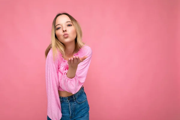 Foto van jonge positieve gelukkig mooie blonde vrouw met oprechte emoties dragen roze blouse geïsoleerd op roze achtergrond met kopieerruimte en het geven van kus — Stockfoto