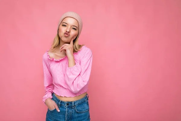 Shot of charming amusing joyful happy young blonde woman isolated over pink background wall wearing trendy pink hat and pink blouse looking at camera and having fun — Stock Photo, Image