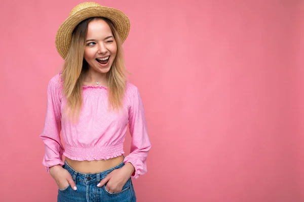 Foto-Foto von jungen schönen niedlichen glücklich blonde Frau trägt stilvolle rosa Crop Top und Strohhut isoliert über rosa Hintergrund mit Kopierraum — Stockfoto