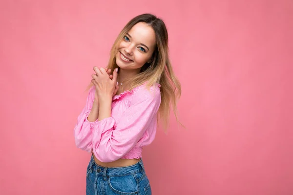 Jonge mooie vrouw. Trendy vrouw in modieuze roze gewas top. Positieve vrouw toont gezichtsemoties. Grappig model geïsoleerd op roze achtergrond met vrije ruimte — Stockfoto