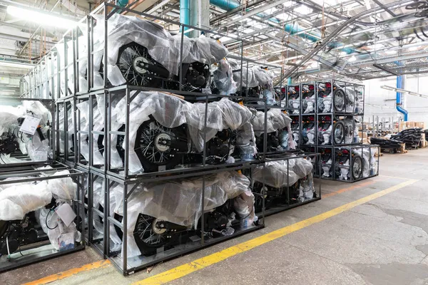 Muchas motocicletas nuevas en paquetes en la planta de ensamblaje de motocicletas y ciclomotores — Foto de Stock