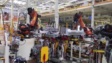 Bir otomobil üretim hattındaki robotların işi, modern büyük bir fabrika.