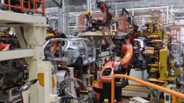 Robotlar, modern bir yüksek teknoloji fabrikasında araba parçaları üretiyorlar.