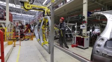 Borisov, Belarus - 29 Ekim 2021: işçiler bir araba parçasını modern bir fabrikaya taşıdı.