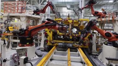 Otomatik kaynak robotlarının modern bir fabrikanın konveyöründe çalışması