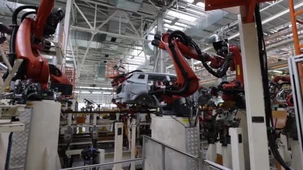 Fábrica de automóveis, produção com a participação de robôs, soldagem de um corpo de carro — Vídeo de Stock