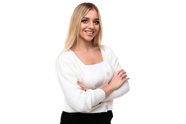 Foto de una hermosa mujer rubia feliz sonriente positiva bastante increíble con maquillaje en un elegante suéter de punto blanco y pantalones negros con manos cómodas aisladas sobre un fondo blanco con copia —  Fotos de Stock