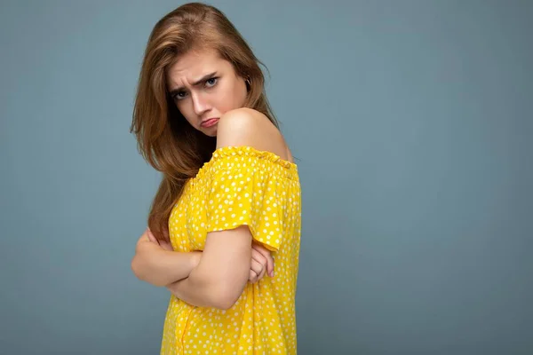 Foto de joven linda encantadora hermosa atractiva triste insatisfecha infeliz mujer rubia oscura con emociones sinceras aisladas en la pared de fondo azul con espacio de copia para el texto con estilo amarillo — Foto de Stock