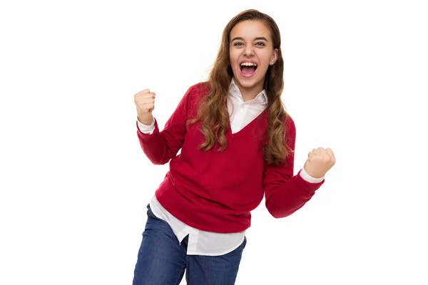 Φωτογραφία από όμορφο χαριτωμένο γοητευτικό χαμογελαστό ευτυχισμένη μελαχρινή έφηβη κοπέλα με μακριά μαλλιά σε κομψό κόκκινο πουλόβερ και λευκό πουκάμισο γιορτάζει τη νίκη και φωνάζοντας ναι απομονώνονται σε λευκό φόντο με δωρεάν — Φωτογραφία Αρχείου