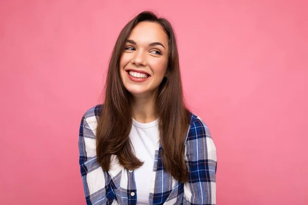 Φωτογραφία πορτρέτο του νεαρού όμορφο χαμογελαστό hipster μελαχρινή γυναίκα σε μοντέρνο μπλε και άσπρο πουκάμισο. Σέξι ξέγνοιαστη γυναίκα που ποζάρει απομονωμένη κοντά σε ροζ τοίχο με άδειο χώρο στο στούντιο. Θετικό μοντέλο — Φωτογραφία Αρχείου