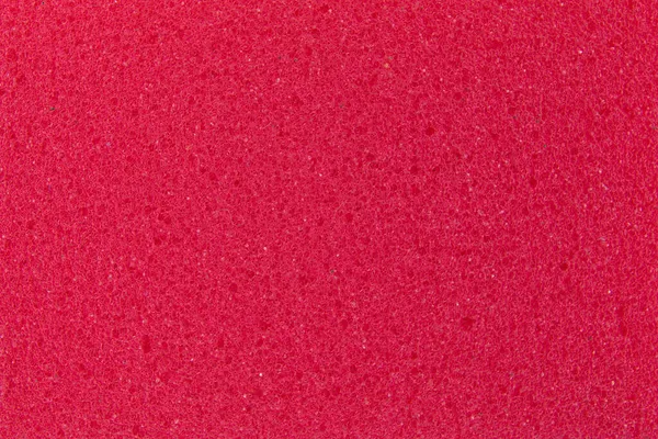 Фон красной губки для мытья посуды, крупным планом, пористой поверхностью — стоковое фото