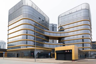 Yeraltı otoparkının girişi modern bir ofis binasının arka planında, genel plan