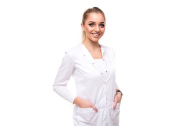 Güzel, seksi, çekici, pozitif, gülümseyen, at kuyruğu ve makyajlı sarışın bir kadının fotoğrafı. Beyaz bir arka planda izole edilmiş beyaz bir hemşirenin beyaz önlüğü içinde.